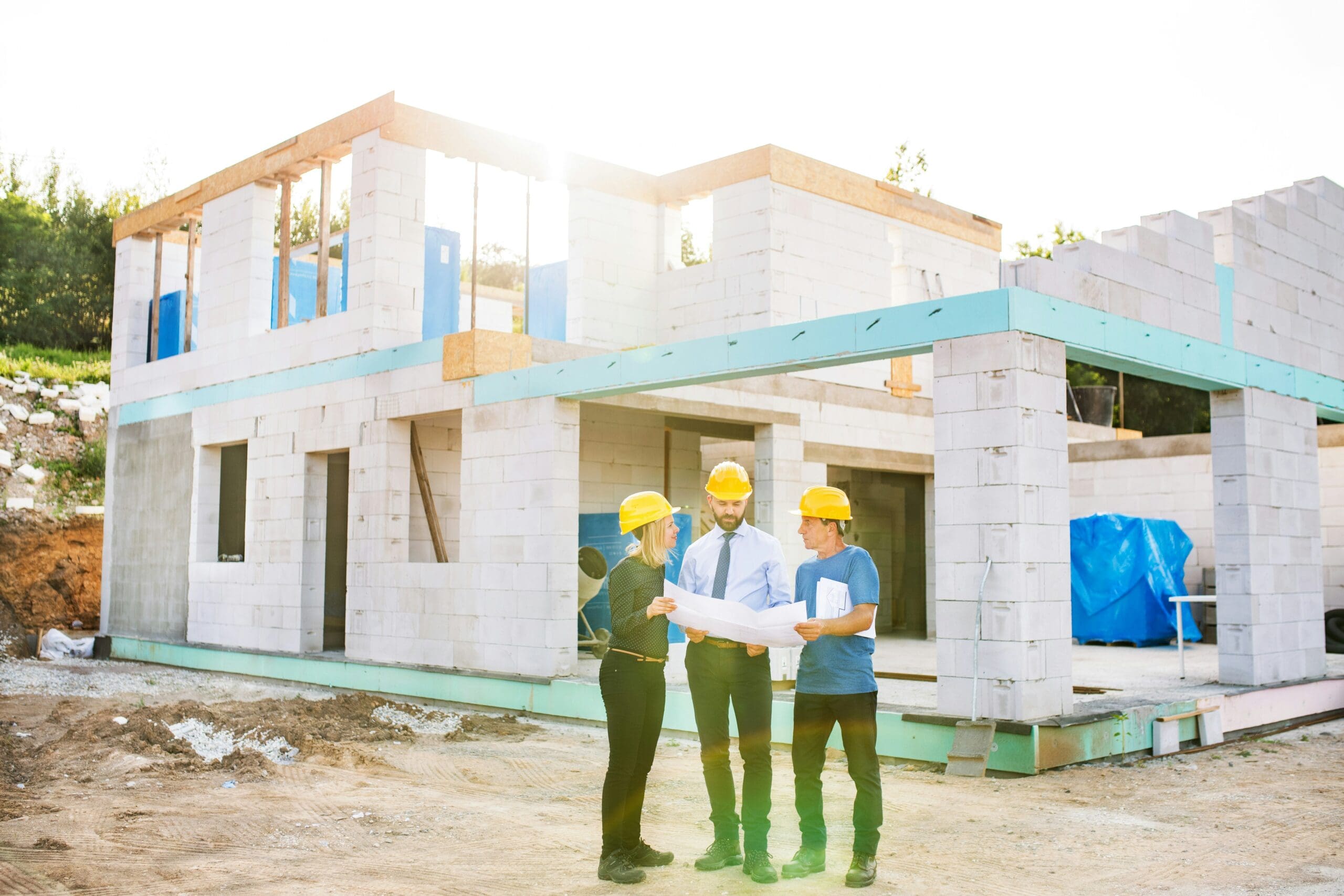 Baustelle mit Bauherren, Architekten und Handwerkern bei der Bauplanung – typische Haftungsrisiken für Dritte im Rahmen der Bauherrenhaftpflichtversicherung